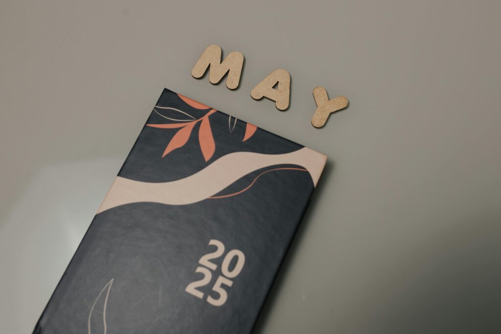 Modern 2025 planner with wooden cutout May letters on a minimalist background.